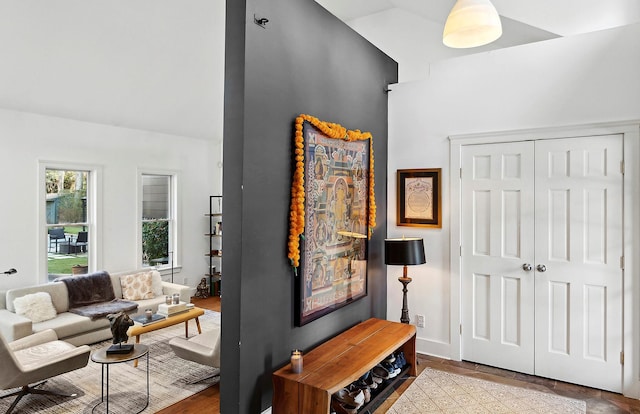 living room featuring lofted ceiling and light wood-type flooring