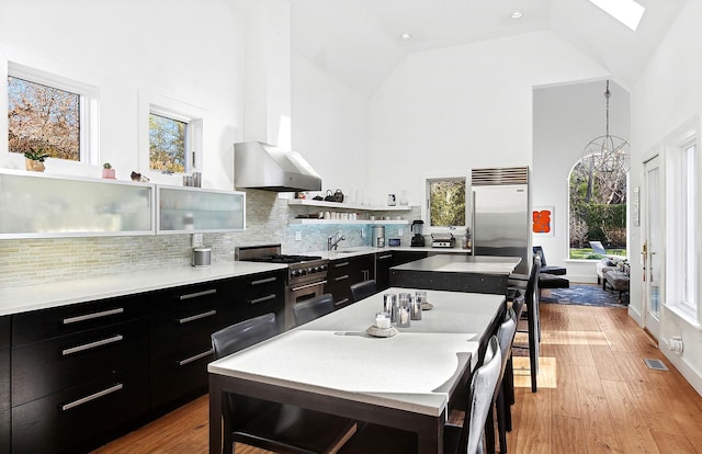 kitchen featuring a healthy amount of sunlight, a kitchen island, and high vaulted ceiling