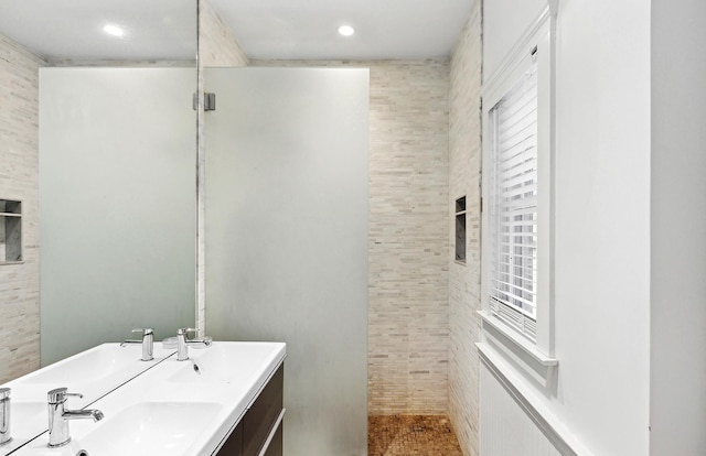 bathroom featuring a tile shower and sink