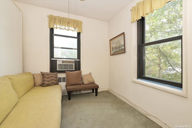 sitting room with carpet flooring, radiator heating unit, and cooling unit