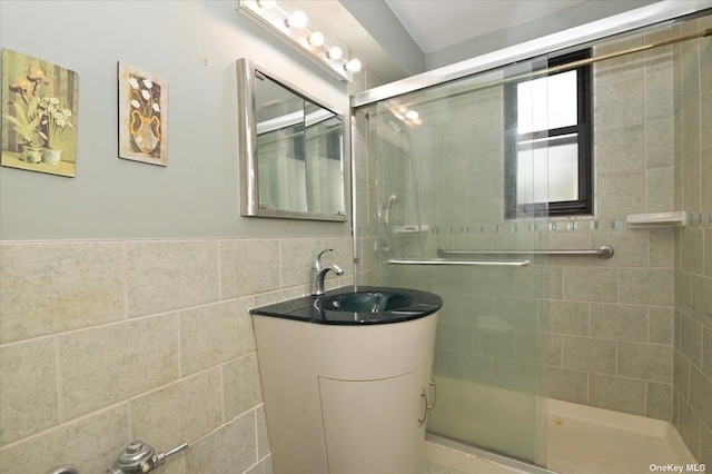 bathroom with vanity, tile walls, and walk in shower