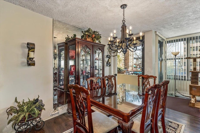 dining room featuring a chandelier, dark wood-type flooring, and a textured ceiling