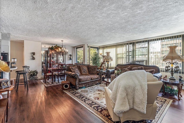 living room with a notable chandelier, dark hardwood / wood-style floors, a textured ceiling, and expansive windows