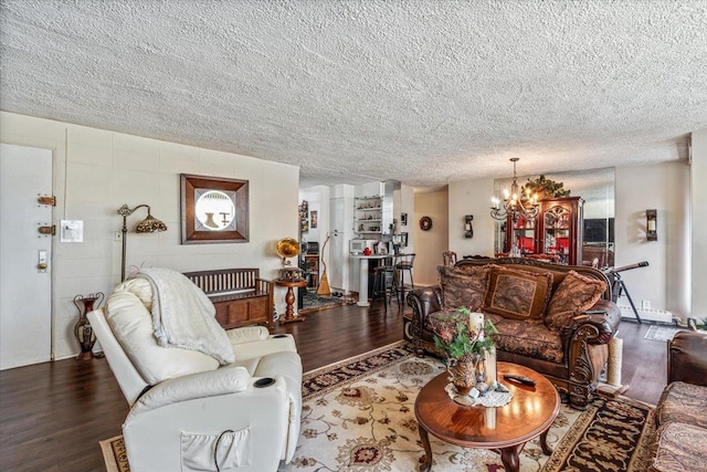 living room with dark hardwood / wood-style flooring, a textured ceiling, and a chandelier