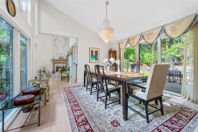 45 Bristol Dr, Manhasset, NY 11030 - dining area featuring high vaulted ceiling, a notable chandelier, wood finished floors, and a fireplace