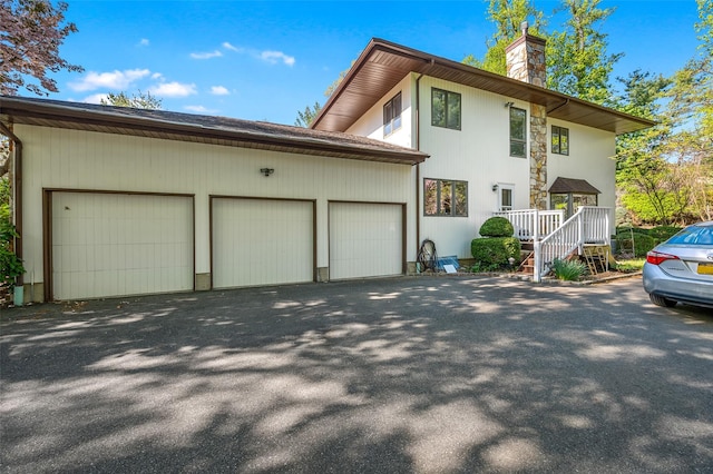 45 Bristol Dr, Manhasset, NY 11030 - exterior space with a garage, a chimney, and aphalt driveway
