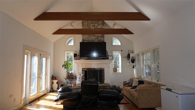 living room with plenty of natural light, beam ceiling, and high vaulted ceiling