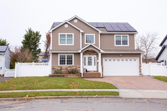 8 Lillian Ln, Plainview, NY 11803 - view of front facade featuring stone siding, decorative driveway, roof mounted solar panels, an attached garage, and a gate