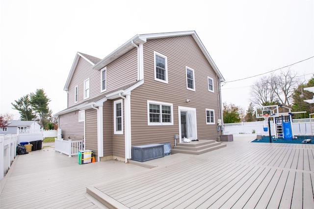 rear view of house with a playground and a deck