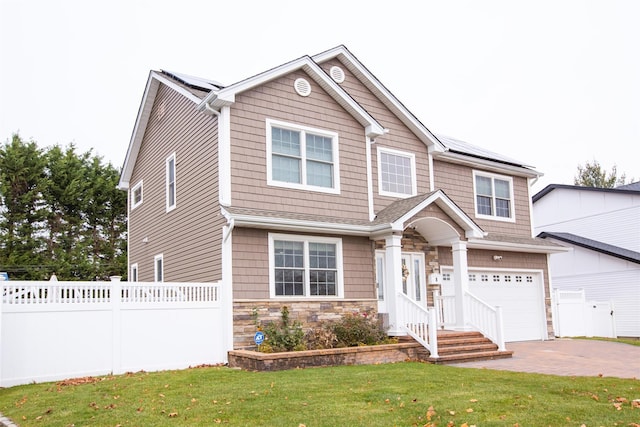 view of front of home with solar panels, a garage, and a front yard