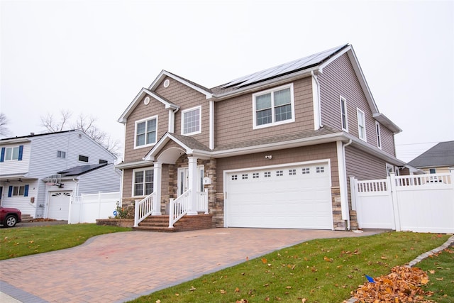 8 Lillian Ln, Plainview, NY 11803 - view of front of home featuring an attached garage, roof mounted solar panels, stone siding, and decorative driveway