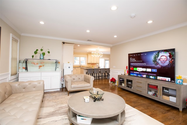 living room with a chandelier, wood-type flooring, and crown molding