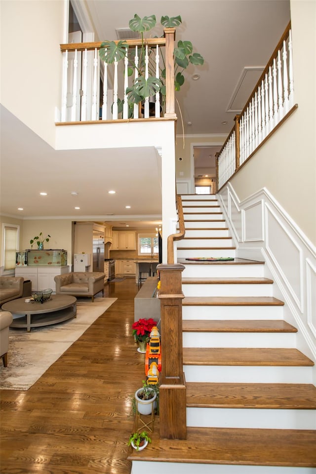 stairs featuring hardwood / wood-style floors and crown molding