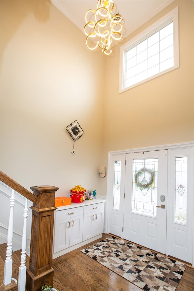 8 Lillian Ln, Plainview, NY 11803 - entryway with a chandelier, wood finished floors, plenty of natural light, a towering ceiling, and ornamental molding
