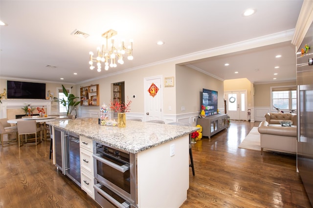8 Lillian Ln, Plainview, NY 11803 - kitchen featuring open floor plan, a decorative wall, ornamental molding, a chandelier, and a kitchen breakfast bar