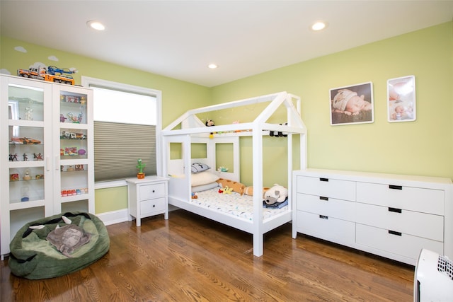 bedroom with dark hardwood / wood-style floors