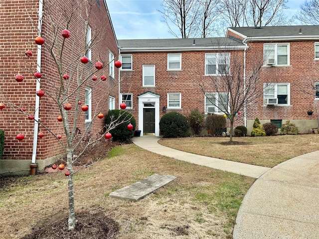 view of front of property featuring a front lawn and cooling unit