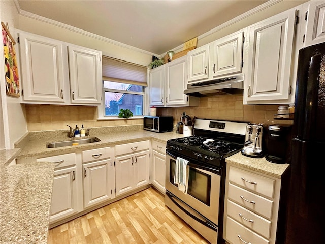 kitchen featuring black fridge, sink, light hardwood / wood-style floors, white cabinetry, and stainless steel range with gas stovetop