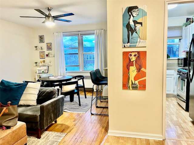 dining area featuring radiator, ceiling fan, and light hardwood / wood-style floors