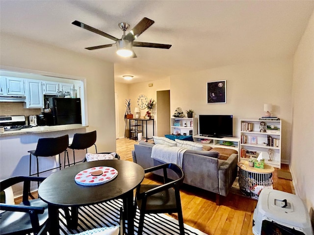 living room featuring ceiling fan and light hardwood / wood-style floors