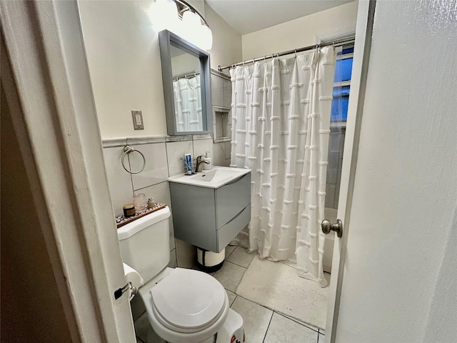 bathroom featuring tile patterned flooring, vanity, tile walls, and toilet