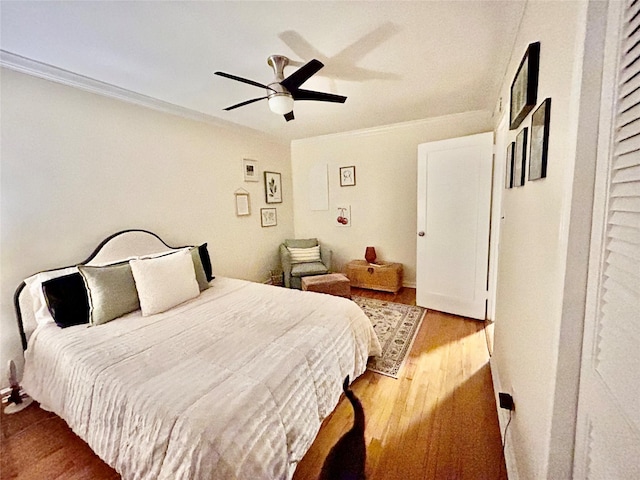 bedroom featuring ceiling fan, light hardwood / wood-style flooring, and crown molding