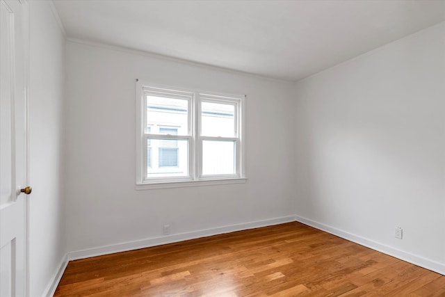 spare room featuring light hardwood / wood-style floors and ornamental molding