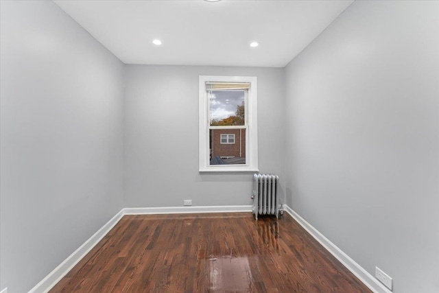 empty room featuring dark hardwood / wood-style flooring and radiator