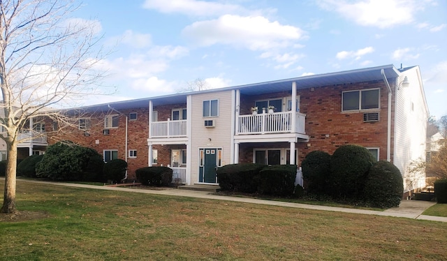 view of front of property with a balcony and a front lawn