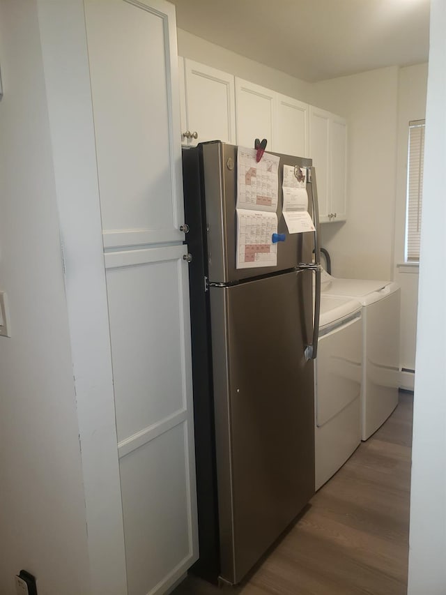 washroom featuring hardwood / wood-style flooring, cabinets, independent washer and dryer, and baseboard heating