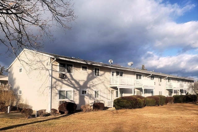 back of property featuring a yard and a balcony