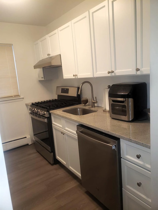 kitchen with white cabinets, dark hardwood / wood-style flooring, stainless steel appliances, and a baseboard heating unit