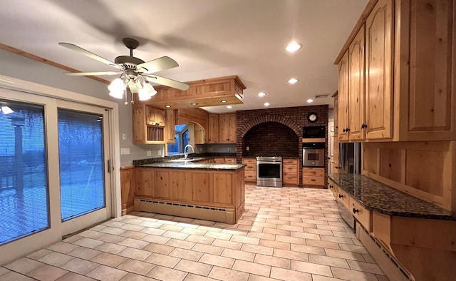 kitchen featuring kitchen peninsula, appliances with stainless steel finishes, ceiling fan, sink, and a baseboard radiator