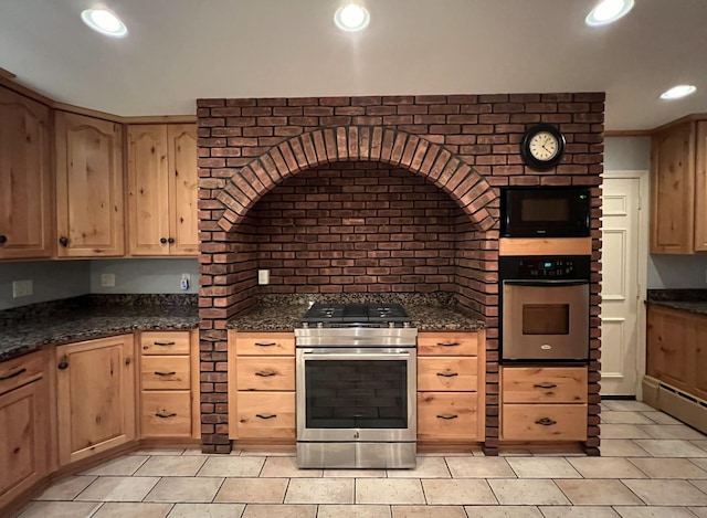 kitchen with dark stone counters and appliances with stainless steel finishes