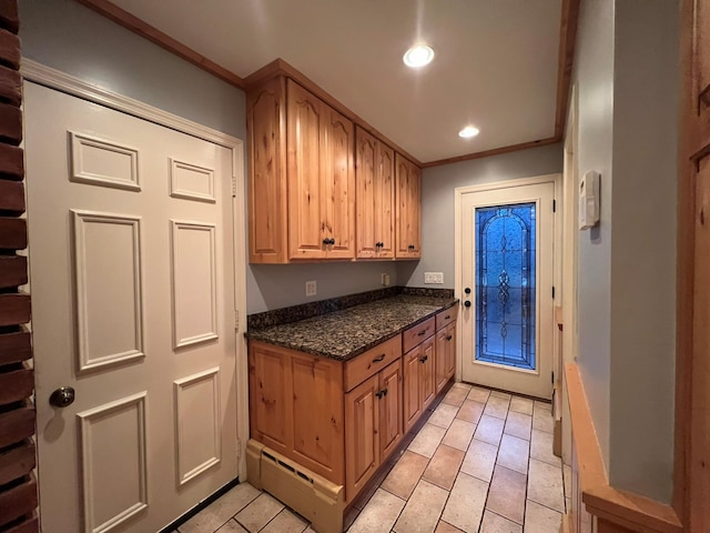 kitchen with dark stone countertops and crown molding