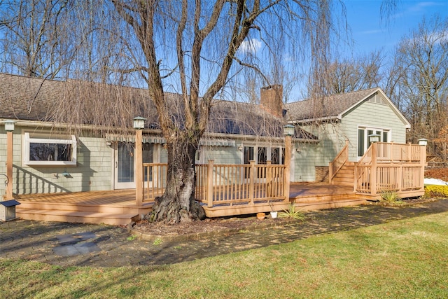 rear view of property featuring a deck and a yard