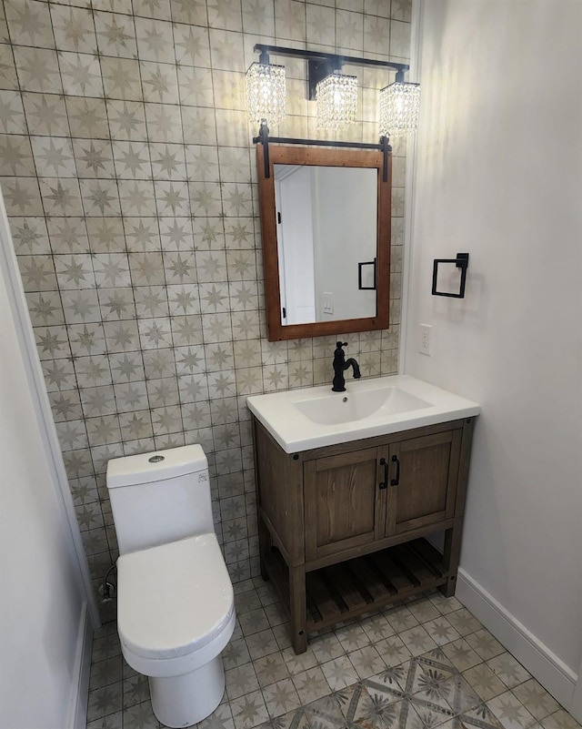 bathroom with tile patterned flooring, vanity, toilet, and tile walls