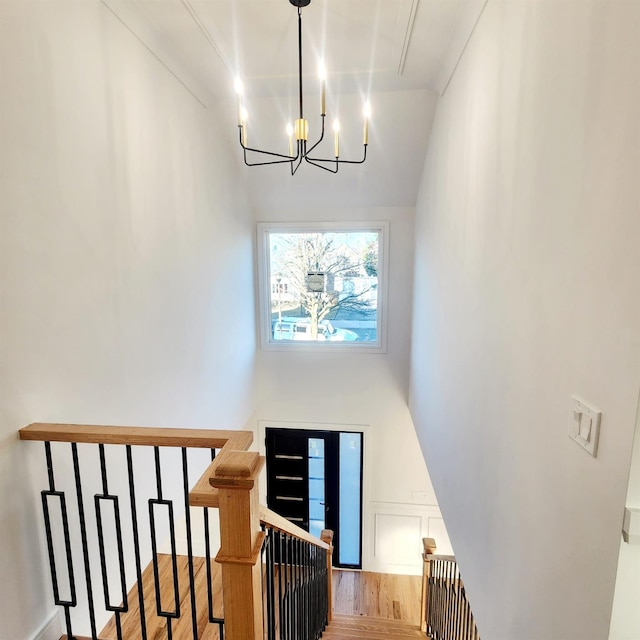 staircase featuring a chandelier and hardwood / wood-style flooring