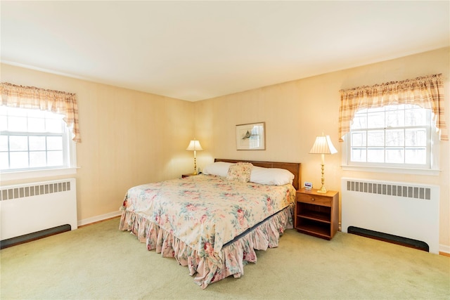 bedroom featuring carpet, radiator heating unit, and multiple windows