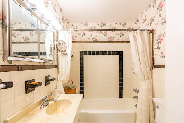 full bathroom featuring shower / bath combination with curtain, toilet, tile walls, and sink