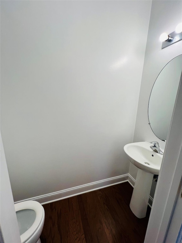 bathroom with hardwood / wood-style flooring and toilet