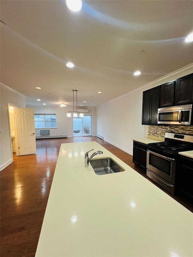 kitchen with stainless steel appliances, tasteful backsplash, sink, hanging light fixtures, and dark hardwood / wood-style floors