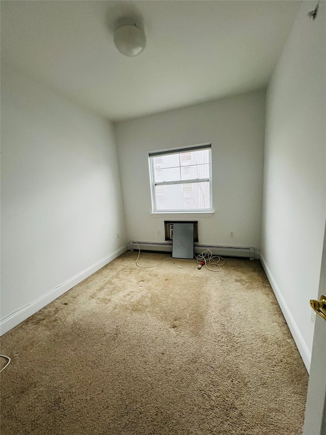 carpeted spare room featuring a baseboard heating unit