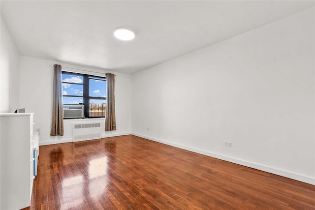 spare room featuring radiator heating unit, cooling unit, and wood-type flooring