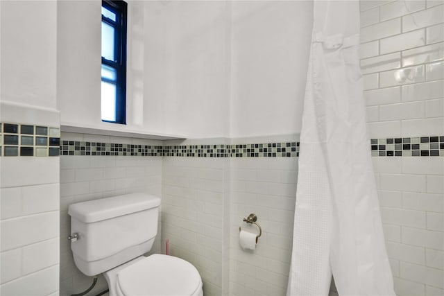 bathroom featuring toilet, tile walls, and walk in shower