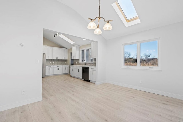 kitchen featuring dishwasher, backsplash, white cabinets, hanging light fixtures, and vaulted ceiling