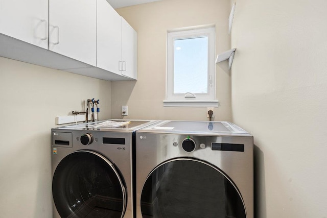 laundry area with cabinets and washing machine and clothes dryer