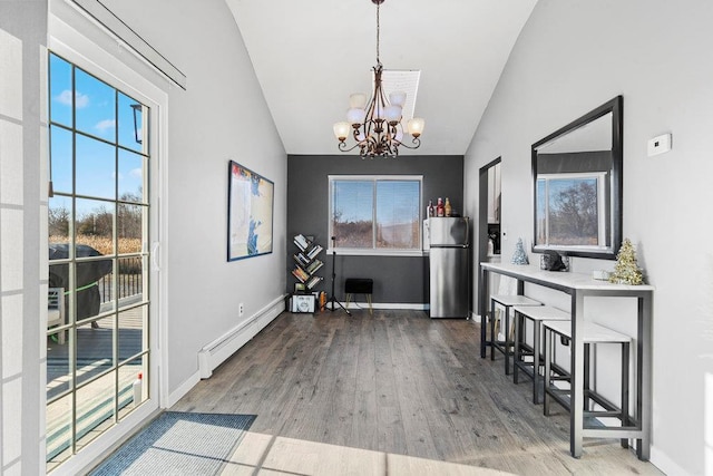 interior space featuring hardwood / wood-style flooring, a notable chandelier, lofted ceiling, and a baseboard heating unit