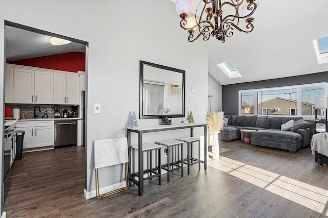 interior space with white cabinetry, dishwasher, tasteful backsplash, dark hardwood / wood-style flooring, and vaulted ceiling with skylight