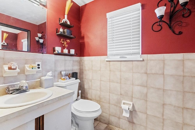 bathroom featuring sink, tile walls, and toilet